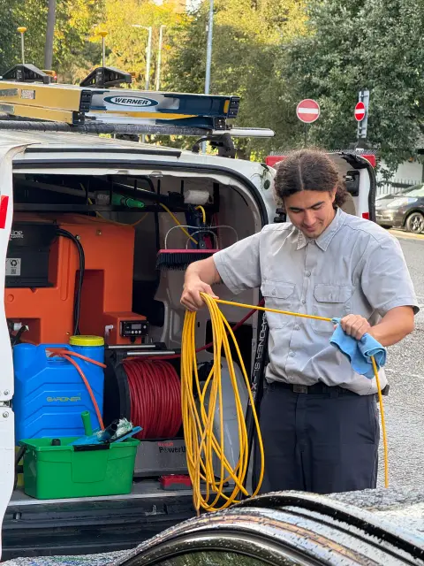 New Wave Cleaning technician packing away the water-fed pole hose